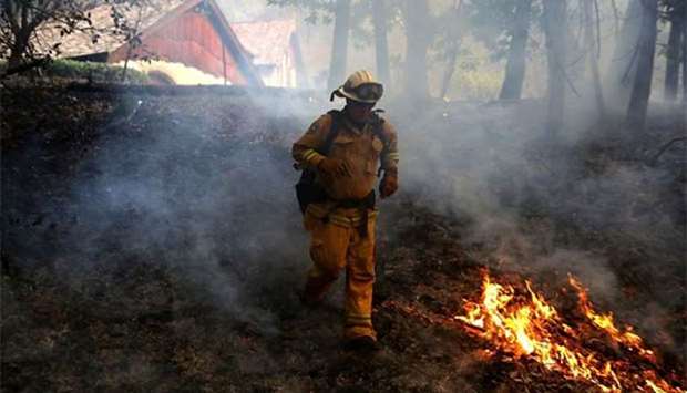 A Cal Fire chief runs past burning grass while battling wildfire near Calistoga, California.