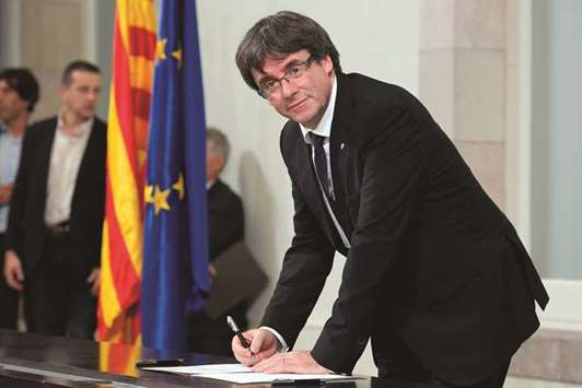 Catalan regional government president Carles Puigdemont signs a document about the independence of Catalonia at the Catalan regional parliament in Barcelona on October 10. Cataloniau2019s leader Carles Puigdemont said he accepted the u201cmandate of the peopleu201d for the region to become u201can independent republic,u201d but proposed suspending its immediate implementation to allow for dialogue.