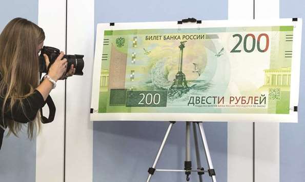 This picture taken on Thursday shows a photographer taking a pictures of the new 200-rouble banknote during the unveiling in Moscow.