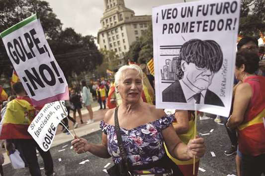 A woman holds a placard with a caricature of Puigdemont during a demonstration in Barcelona on Thursday called by the Catalan Civil Society, under the motto u2018Catalonia yes, Spain toou2019.