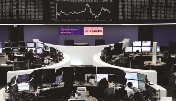 Traders working inside the Frankfurt Stock Exchange. The DAX 30 ended 0.1% up at 12,991.87 points yesterday.