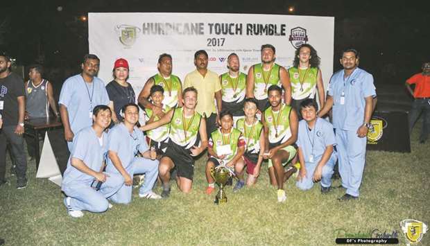 Chiefs players celebrate with the winnersu2019 trophy and officials after the Hurricane Touch Rugby Rumble Cup final on Friday.