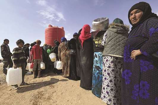 Displaced Syrians collect water from a tank at a camp housing people who fled the fighting in Deir Ezzor, Mayadeen and Albu Kamal, yesterday, in the town of Arisha in the neighbouring province of Hasakeh.