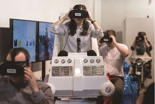 Visitors take a virtual reality ride called The Fair Grounds at u2018The Arts+u2019 section of the Frankfurt Book Fair.