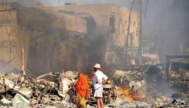 A man and a woman look at the damage to a building following a truck bomb explosion in Mogadishu on Saturday.