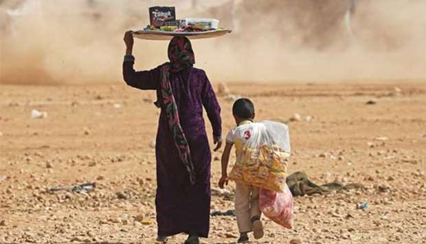 A mother and a child sell foodstuff at a refugee camp for people displaced in fighting between the Syrian Democratic Forces and Islamic State militants in Ain Issa, Syria on Saturday.
