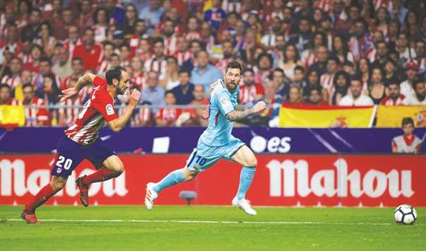 Barcelonau2019s Lionel Messi runs with the ball as Atletico Madridu2019s Juanfran chases him during the Spanish La Liga match at the Wanda Metropolitano stadium in Madrid on Saturday night. (Reuters)