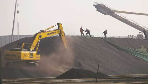 Labourers work on a pile of iron ore at a steel factory in Tangshan, China. Iron ore imports by China surged above 100mn metric tonnes to a record, smashing the previous high set in 2015, as the countryu2019s concerted push to clean up the environment stoked demand for higher-grade material from overseas while hurting local mine supply.