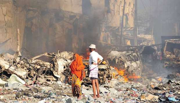 A man and woman look at the damages on the site of the explosion of a truck bomb in the centre of Mogadishu late on Saturday.