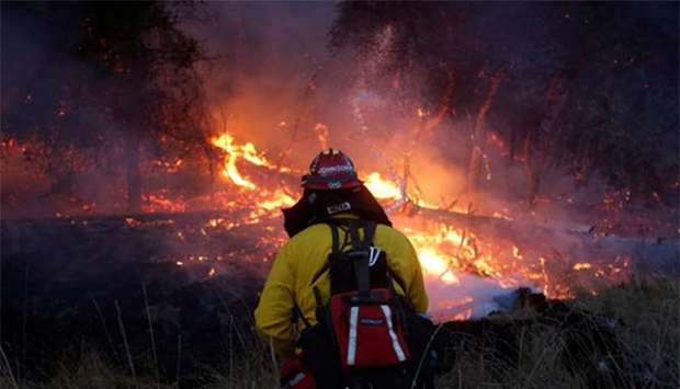 A firefighter watches as a wildfire takes hold near Santa Rosa, California on Saturday.