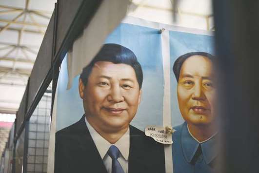 Portraits of Chinese President Xi Jinping (left) and late communist leader Mao Zedong at a market in Beijing.
