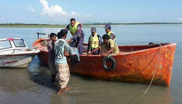 Bangladesh coastguard hand over bodies to Bangladeshi locals after recovering it from the Naf river estuary on Monday.