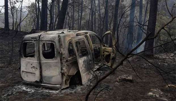 The wreckage of a burned van where two people died trapped by flames is pictured in Chandebrito, near the town of Nigran, northwestern Spain, on Monday.