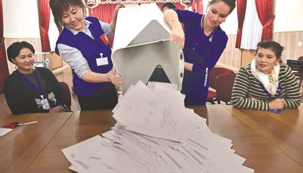 Members of a local election committee empty a ballot box at a polling station in Bishkek.