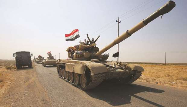 Iraqi forces drive towards Kurdish Peshmerga positions yesterday, on the southern outskirts of Kirkuk.