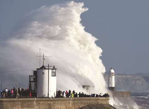 Waves crash over the lighthouse as storm Ophelia passes Porthcawl, Wales, Britain, yesterday.