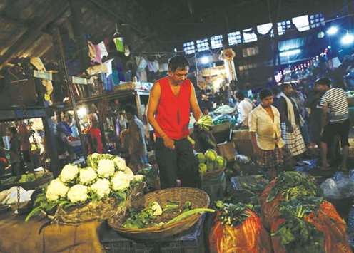 A vendor sorts out cabbages at his stall at a wholesale vegetable market in Mumbai yesterday. Cooling of food prices helped ease Indiau2019s annual rate of inflation in September.