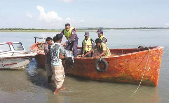 Bangladesh coast guards hand over recovered body to locals after recovering it from the Naf river estuary near Shah Porir Dwip in Teknaf yesterday.