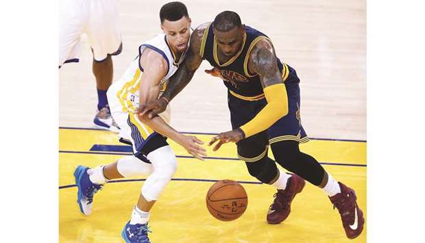 This file picture taken on June 1, 2016 shows Golden State Warriors guard Stephen Curry (left) and Cleveland Cavaliers forward LeBron James scrambling for a loose ball during the second quarter of Game 1 of the NBA Finals in Oakland, California. (AFP)