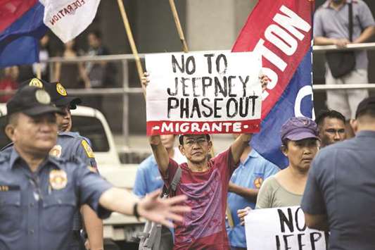 Activists and jeepney drivers hold banners during a jeepney transport strike held in Manila yesterday.