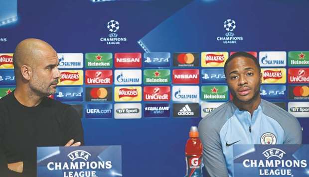 Manchester City manager Pep Guardiola (left) watches as midfielder Raheem Sterling speaks at a press conference in Manchester yesterday. (AFP)
