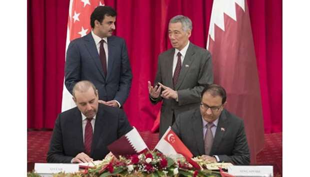 His Highness the Emir Sheikh Tamim bin Hamad al-Thani and the Prime Minister of Singapore Lee Hsien Loong attend the signing of an agreement.