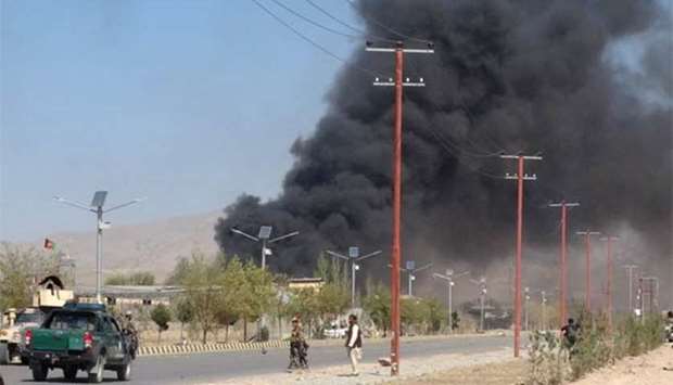 Smoke rises from police headquarters while Afghan security forces keep watch after a suicide car bomber and gunmen attacked the provincial police headquarters in Gardez, the capital of Paktia province, on Tuesday.
