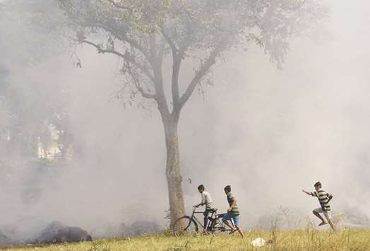 Boys play next to a field of burning leaves and agricultural waste in Jalandhar, Punjab. The burning of waste agricultural products is major factor in the air pollution crisis in Delhi and neighbouring states.