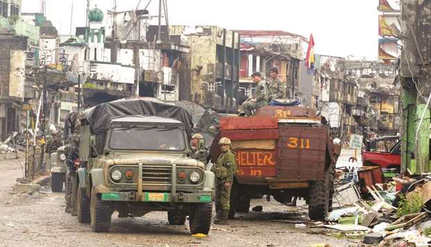 Government troops guard in front of destructed houses and buildings in Bangolo town, Marawi city.