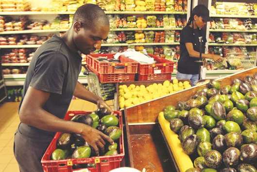 Workers pack out avocados at a fruit and vegetable market store in Harare.