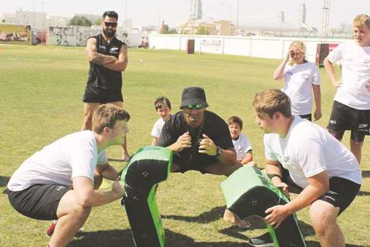 Haka Rugby Camps co-founder Regan Sue (centre) leads a tackling activity.