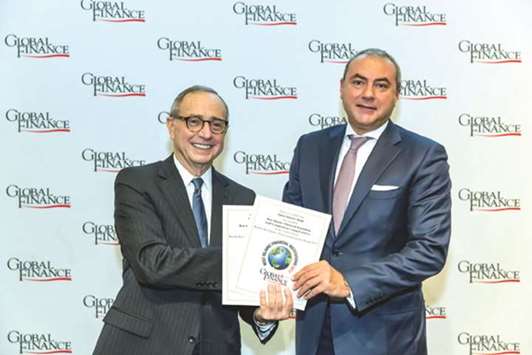 Gamal (right) receiving the award on behalf of QIB from a top executive of Global Finance, in Washington recently.