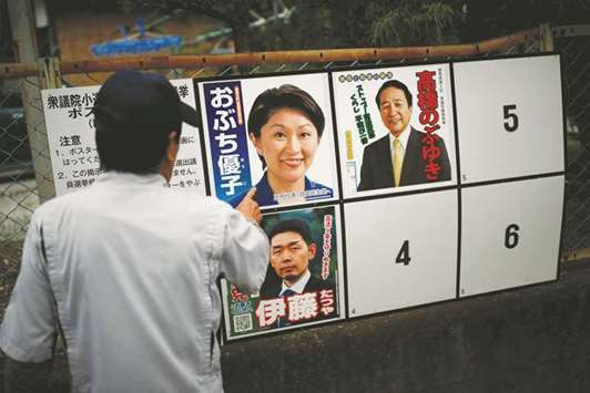 A local resident looks at candidatesu2019 posters for the October 22 lower house election in Nanmoku village, northwest of Tokyo.