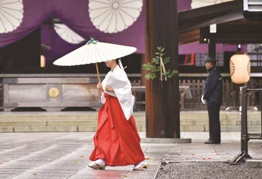 A priestess walks at the controversial Yasukuni Shrine in Tokyo.
