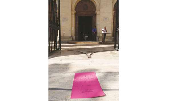 A poster is left at the entrance to the law courts in Valletta after a protest over the death of Caruana Galizia.