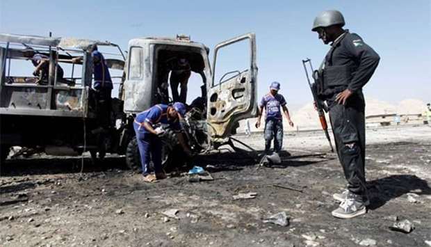 Rescue workers inspect as a policeman stands near a truck after a blast in Quetta on Wednesday.