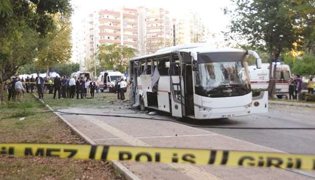 Plainclothes police officers are seen near the bomb-hit bus carrying police officers in Mersin.