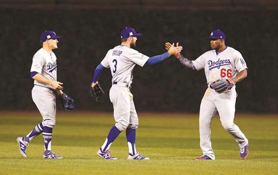 Los Angeles Dodgers outfielders Enrique Hernandez (left), Chris Taylor (centre) and Yasiel Puig celebrate after defeating the Los Angeles Dodgers during game three of the 2017 NLCS playoff baseball series at Wrigley Field. PICTURE: USA TODAY Sports
