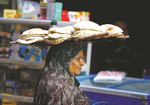A woman carries bread as she leaves a bakery in Cairo. Egyptu2019s economic growth has slowed since the 2011 uprising scared off tourists and foreign investors.