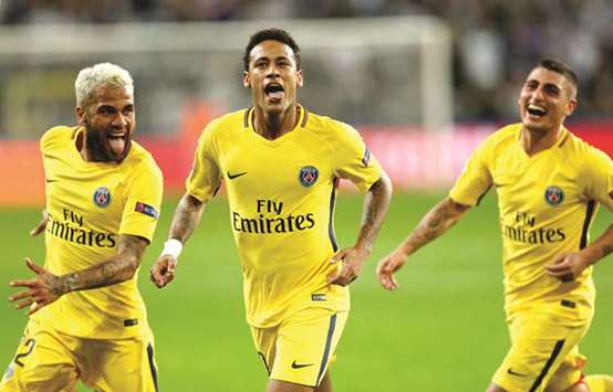Paris Saint-Germainu2019s Neymar (centre) celebrates scoring the teamu2019s third goal with teammates Dani Alves (left) and Marco Verratti during their Champions League match in Brussels, Belgium, yesterday. (Reuters)