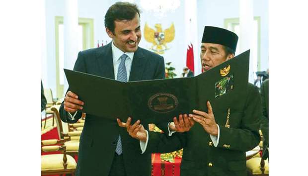 Indonesian President Joko Widodo presents a memento to His Highness the Emir Sheikh Tamim bin Hamad al-Thani.