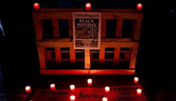 The front page of Tuesday's Times of Malta newspaper is seen during a silent candlelight vigil to protest against the assassination of investigative journalist Daphne Caruana Galizia in a car bomb attack, at the University of Malta in Msida.