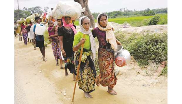 Rohingya refugees, who crossed the border from Myanmar two days earlier, walk after they received permission from the Bangladesh army to continue their way to Kutupalong refugee camp, near Coxu2019s Bazar, Bangladesh.