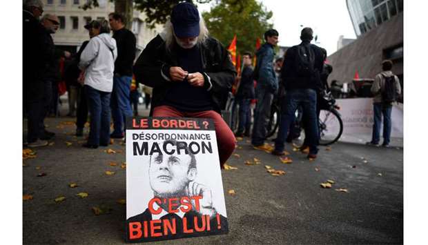 A man sits by a placard prior to a demonstration called by the CGT workersu2019 union against the French presidentu2019s labour law reforms, in Rennes, northwestern France.