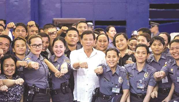 Philippines President Rodrigo Duterte posing for a picture with the Bureau of Jail and Penology Management (BJMP) personnel as he visits a detention cell of the BJMP located within Camp Bagong Diwa in Manila.