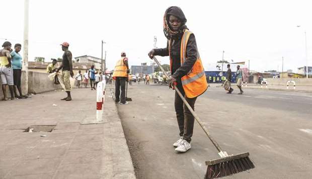 Workers clear a street following a protest in Lome.