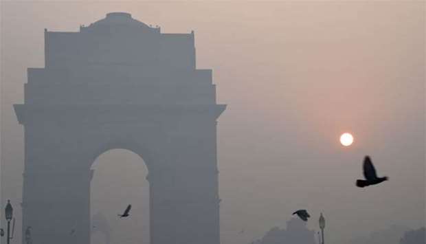 Birds fly near India Gate amid heavy smog in New Delhi on Friday, the day after the Diwali festival.