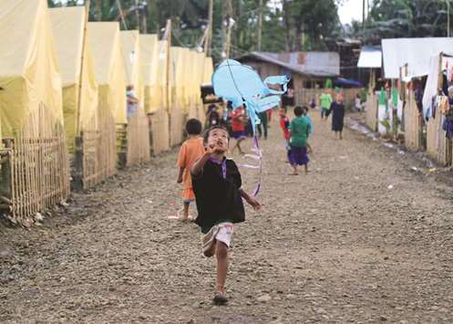 A boy flies a kite in front of a row of tents, a few days after President Rodrigo Duterte announced the liberation of Marawi city, from pro-Islamic State militant groups, at an evacuation site in the municipality of Pantar, Lanao Del Sur, southern Philippines.