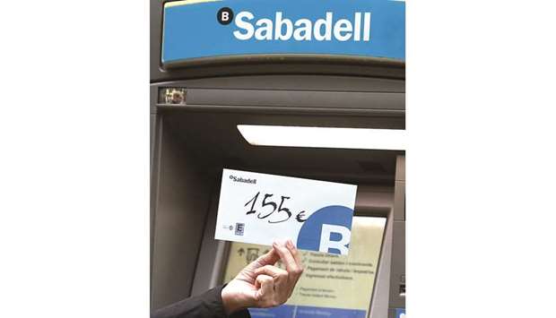 A man holds an envelope with u20ac155 inside after withdrawing that amount from a Banc Sabadell ATM during a protest called by the Catalan National Assembly (ANC) and Omnium Cultural.