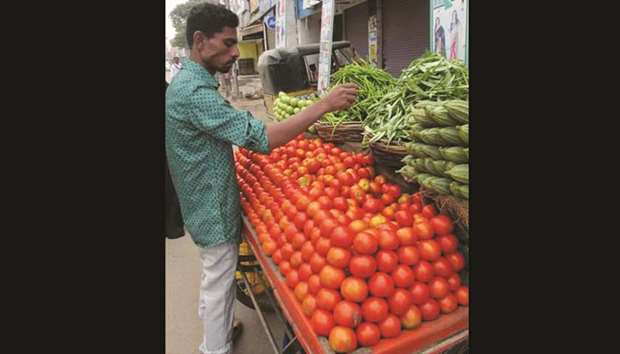 A vendor arranges vegetables at a market in Hyderabad yesterday. Unseasonal rains have led to a sharp rise in prices of vegetables across India.